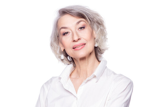 Close up portrait of pleasant grey-haired middle aged female , looking at camera with a wide smile and showing happiness, isolated on white studio background