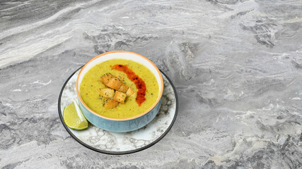 Bowl of delicious lentil soup on a marble floor