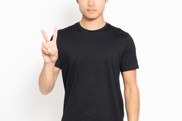 白い背景の前に立って、手で数字の2を表す黒いTシャツを着ている男性