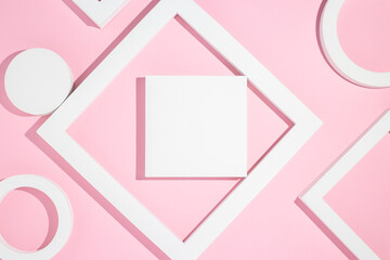 White presentation podiums geometric shapes on a pink background. Top view, flat lay