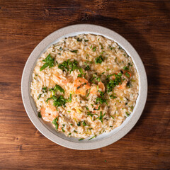 Portion of shrimp risotto in a plate on the table, top view