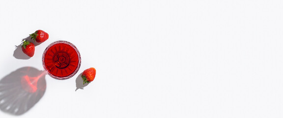 glass with red wine and strawberries on the table on a light background. Top view, flat lay. Banner