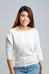 Obraz premium Portrait studio shot of Asian young beautiful pretty female model in long sleeve sexy sweater show naked shoulder and short denim jeans skirt standing smiling look at camera on white background