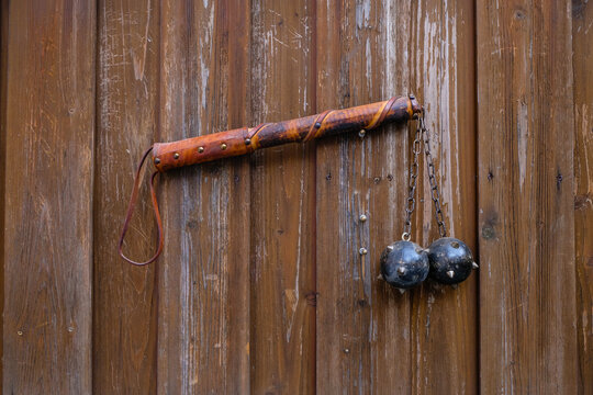 Decorative Morgenstern medieval weapon or mace with spikes. Weapons on wooden gate background.