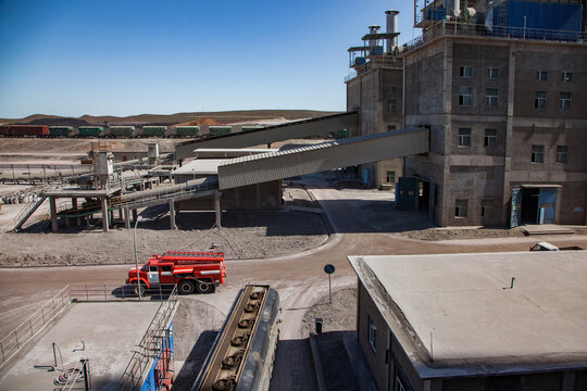 Factory buildings, conveyor, red fire truck and train loading station. Panorama view. Mynaral, Kazakhstan. Jambyl Cement plant. 