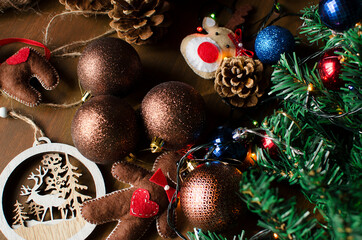 Christmas, New year flatlay composition on wooden background. toys, cone, balls, gingerbread man, deer, tree. Decor of festive table concept