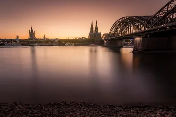 Schöne Aussicht auf die Brücke mit Lichtern in der Nähe des Kölner Doms in Köln bei Nacht © Ikarus/Wirestock