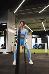 Obraz na płótnie Canvas Athletic woman exercising endurance with ropes