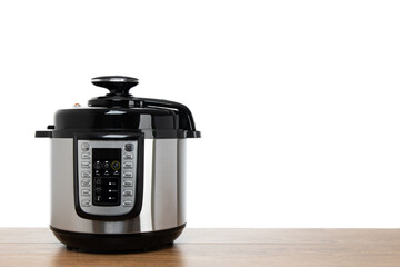 Modern multi cooker on wooden table, isolated