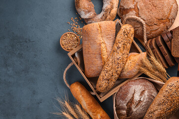 An assortment of wheat and rye flour bread on a graphite background.