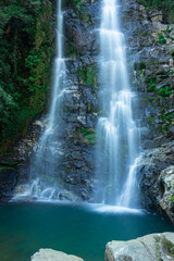waterfall flowing streams falling from mountain with calm blurred water surface long exposure shot