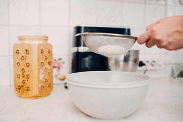 Pastry chef sift pours flour makes cake. Cooking and preparing dessert.