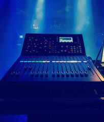 DJ audio mixer in a club under the blue led light