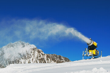 Snow-gun spraying artificial ice crystals. Machine making snow.