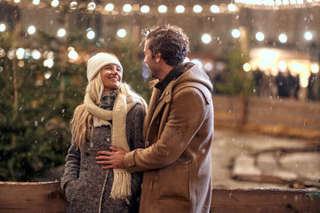 Joyful couple enjoying the winter night; Festive concept