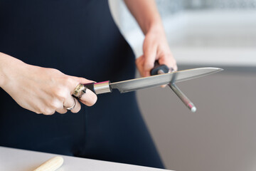 woman sharpening a knife with a grinder