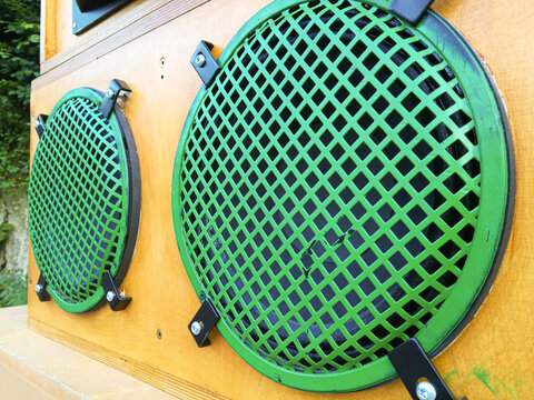Loudspeaker boxes of a music system with strong green protective metal grids