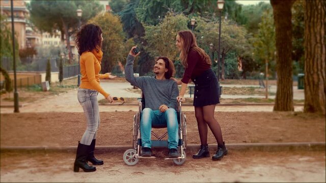 disabled person dancing - man using wheelchair dances with his friends amused
