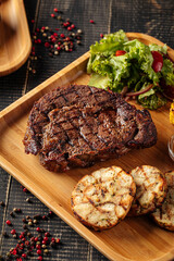 Closeup on grilled beef steak set with salad and sauce