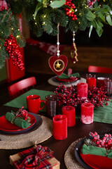 Festive table setting for Christmas eve in red and green colors.