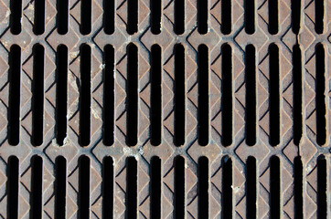 the texture of iron bars with holes. metal sewer on a dark background selective focus