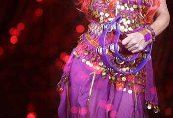 Belly Dancer wearing purple dance costume close up with bokeh