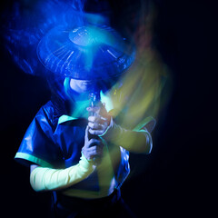 Futuristic character in a bright stylized outfit, with a blaster in his hands. photo with neon...