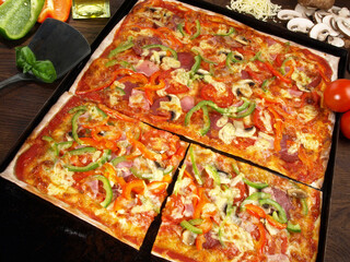 Pizza mit Salami, Schinken und Paprika aus dem Ofen