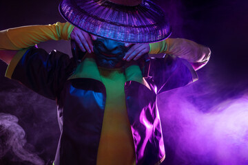 Futuristic character in a bright stylized outfit, wearing an asian mask. photo with neon colors. A...