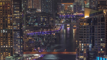 Close up view of Dubai Marina showing canal surrounded by skyscrapers along shoreline night timelapse. DUBAI, UAE