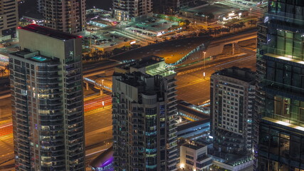 Fototapeta na wymiar Dubai marina towers with traffic on Sheikh Zayed road near metro station night timelapse.
