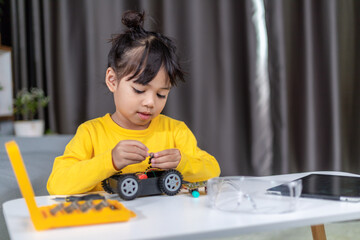Inventive kid constructing robot cars at home