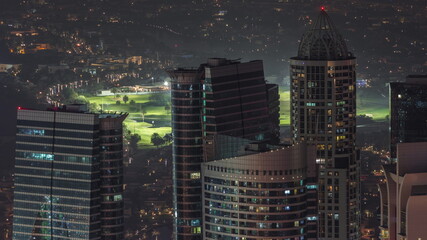 Jumeirah Lakes Towers district with many skyscrapers along Sheikh Zayed Road aerial night timelapse.