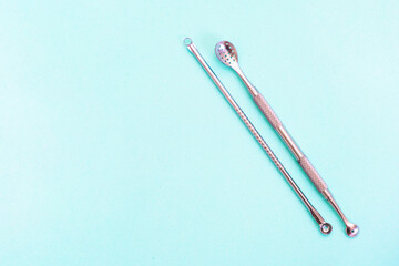 uno spoon for cleansing the face is on a soft turquoise background. flat lay, cosmetology