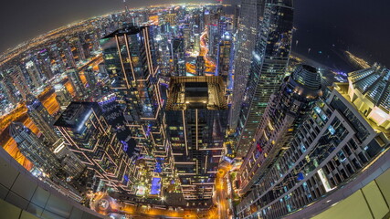 Skyline panorama of Dubai Marina showing canal surrounded by skyscrapers along shoreline night...