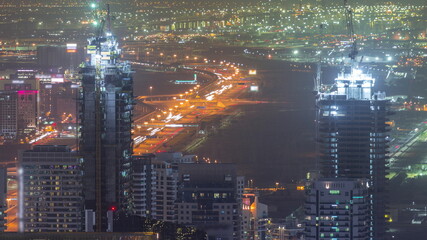 Skyline panoramic view of Dubai Marina showing illuminated skyscrapers and construction site aerial night timelapse. DUBAI, UAE