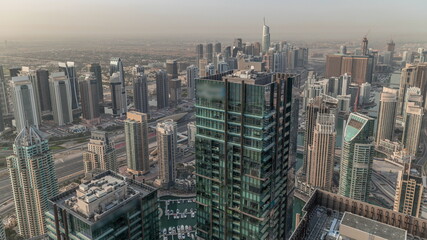 Fototapeta premium Dubai Marina and JLT district with traffic on highway between skyscrapers aerial timelapse.