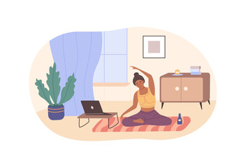 Active flexible woman practicing yoga at home sitting on floor in front of laptop.