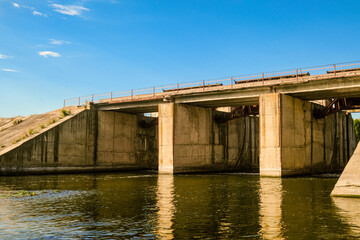 Dam on the Oskol river, Belgorod region, Russia. River surface with concrete banks.