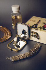 The ring is reflected in the mirror, there are perfumes nearby, a jewelry box, a metal bracelet and...