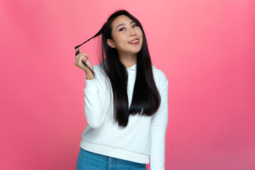 Happy young asian girl twist healthy long hair around finger, flirting. Natural beauty, haircare...