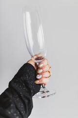 A woman is holding an empty glass
