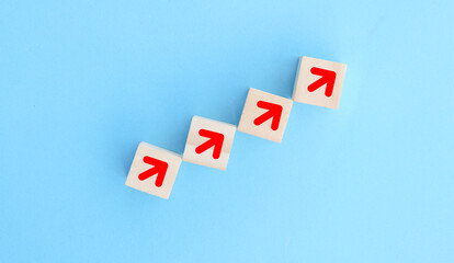 Obraz premium Wooden blocks lined up with up arrow icon The process of creating a successful business idea