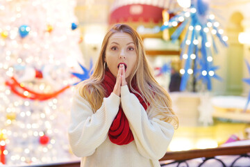 happy blond girl in red scarf with frightened expression and gesture close up portrait on decorated...