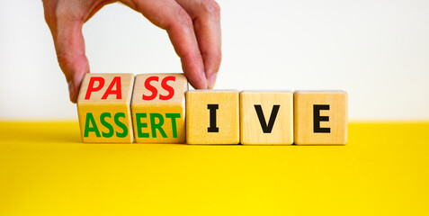 Passive or assertive symbol. Businessman turns wooden cubes and changes the word passive to assertive. Beautiful white background, copy space. Business, psychological passive assertive concept.