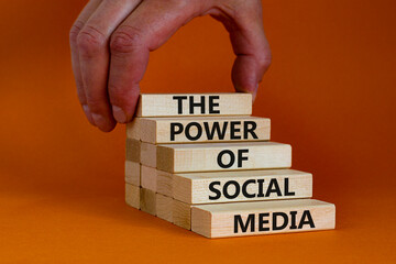 Power of social media symbol. Wooden blocks with words The power of social media. Beautiful orange...