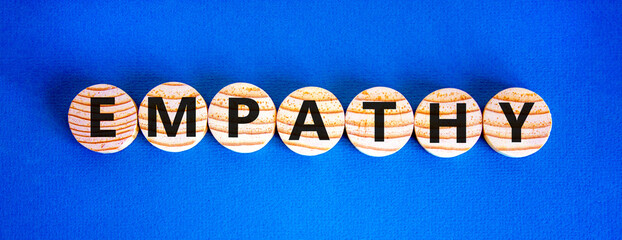 Empathy symbol. The concept word Empathy on wooden circles. Beautiful blue background, copy space. Business, psychological and empathy concept. - obrazy, fototapety, plakaty