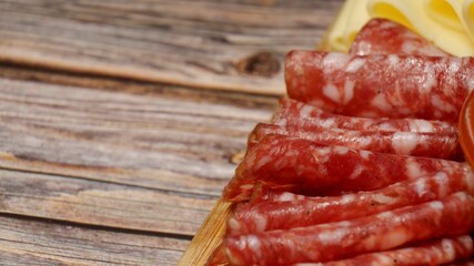 Salami slices rolled on a wooden board
