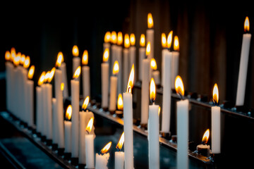 Religion background with burning white candles on fireplace at Church