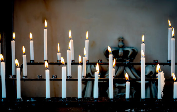 Religion background with burning white candles on fireplace at Church